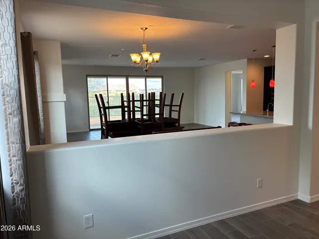 an empty room with wooden floor and chandelier