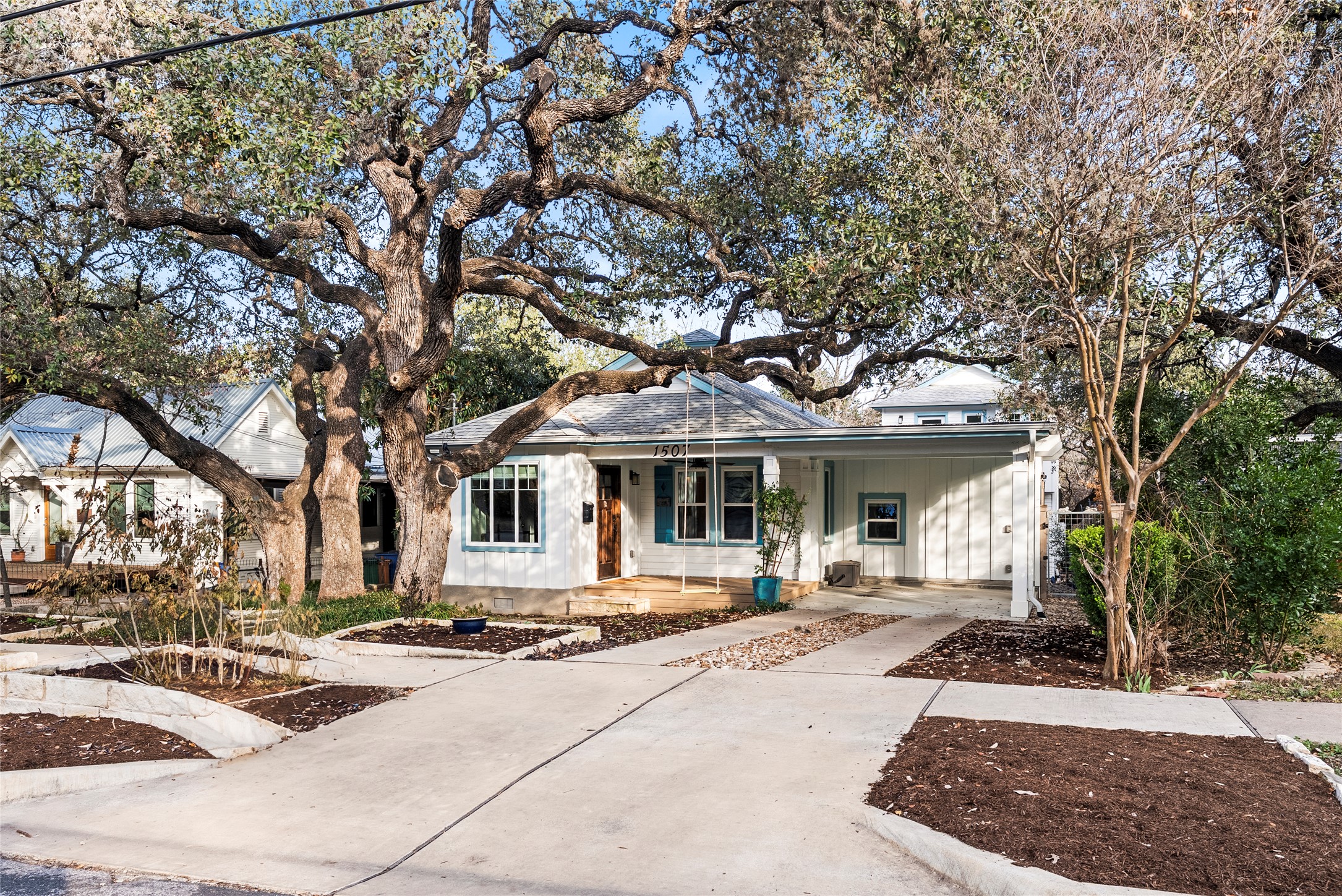 Traditional style house with covered porch, driveway, a carport, and board and batten siding