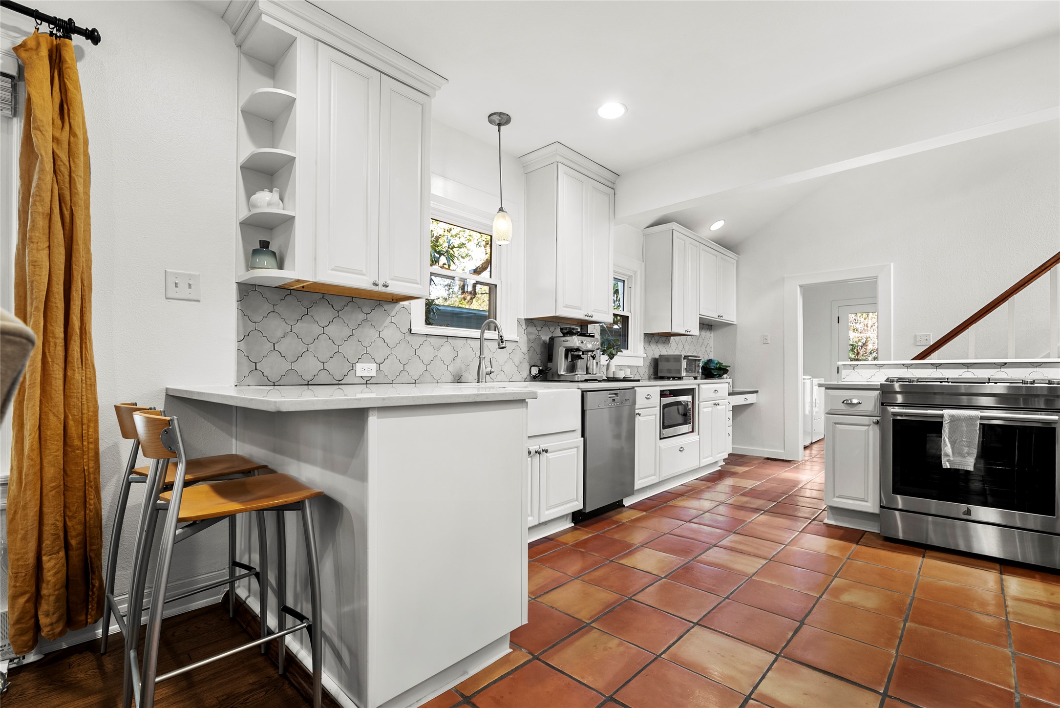 1507 Newning Avenue Austin, TX 78704 - Photo 9 of 37 Kitchen with white cabinetry, stainless steel appliances, decorative light fixtures, a kitchen bar, and recessed lighting