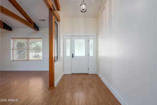 an empty room with wooden floor windows and ceiling fan