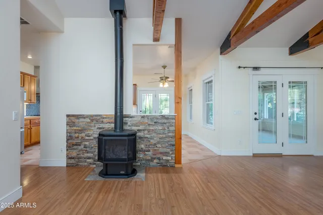 a view of an empty room with wooden floor and a floor to ceiling window
