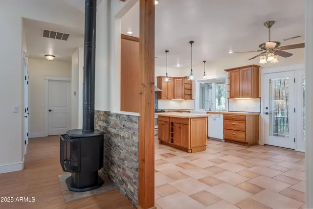 a kitchen with stainless steel appliances granite countertop wooden cabinets a sink a stove a refrigerator and a oven