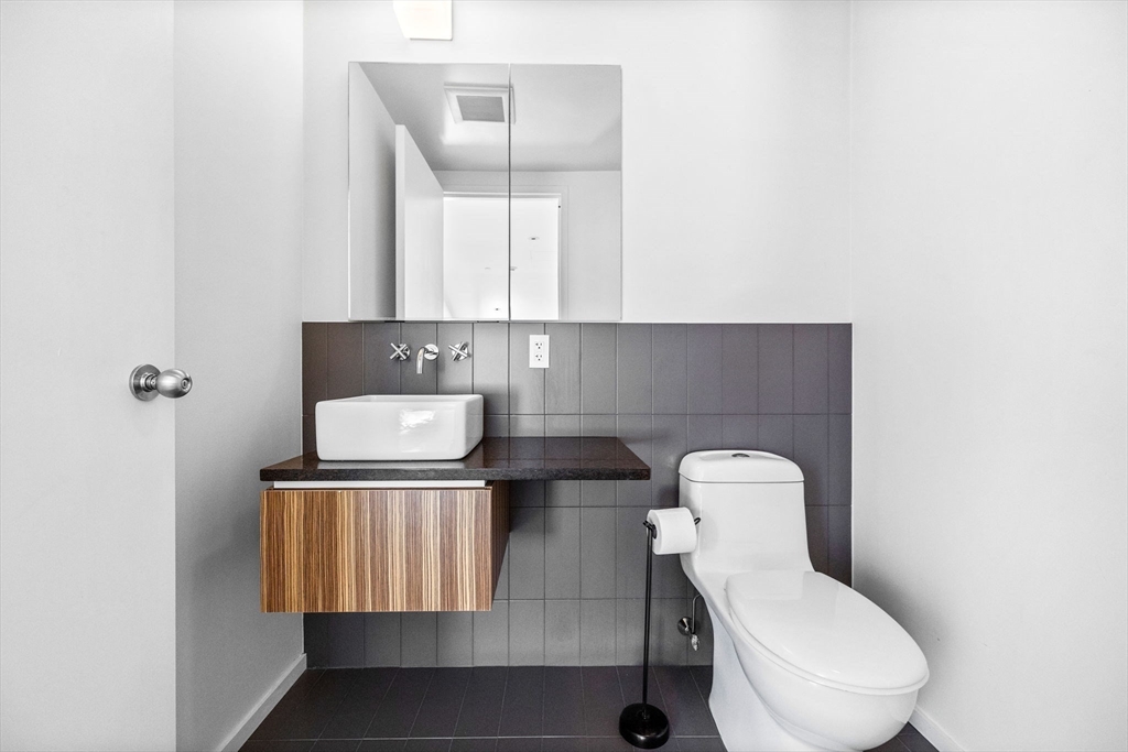 141 Dorchester Avenue, Unit U:616 Boston, MA 02127 - Photo 11 of 23 a bathroom with a toilet mirror and vanity