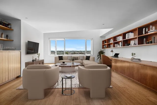 a living room with furniture a rug and a bookshelf