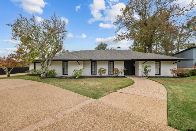 a front view of a house with a yard and trees