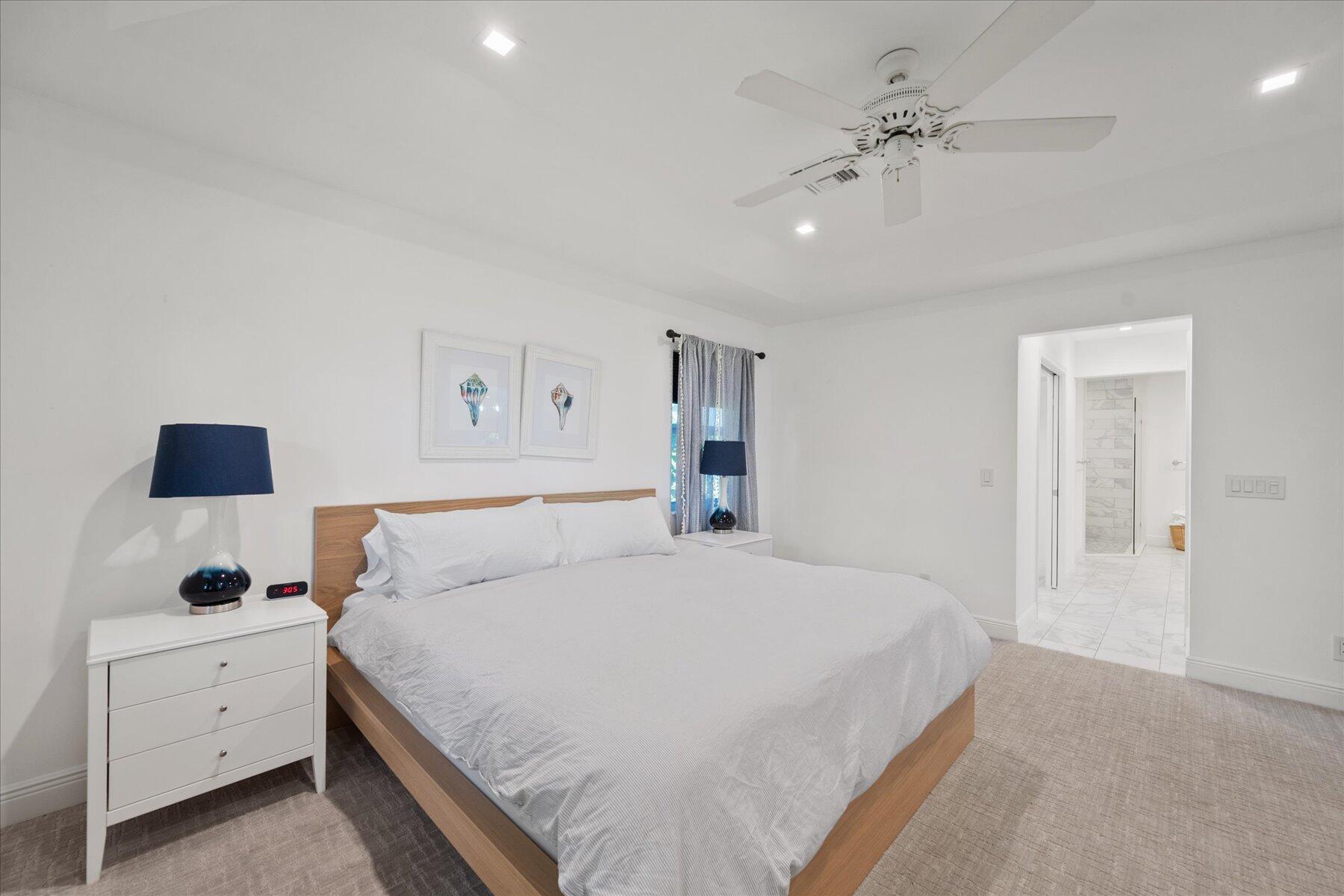 5895 Keith Road Jupiter, FL 33458 - Photo 25 of 51 a spacious bedroom with a bed and a chandelier