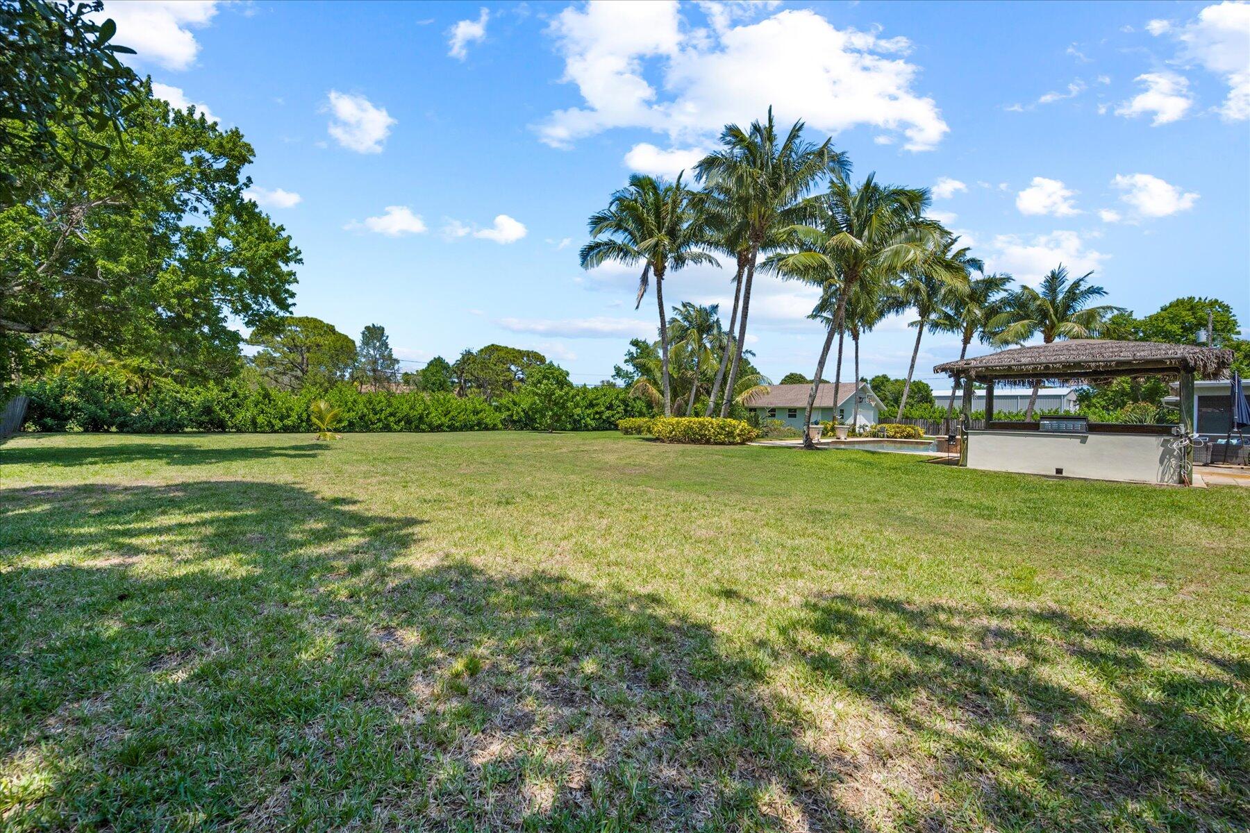 5895 Keith Road Jupiter, FL 33458 - Photo 44 of 51 a view of yard with swimming pool and green space