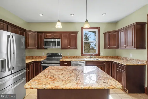 a kitchen with stainless steel appliances granite countertop wooden cabinets a granite counter tops and a refrigerator