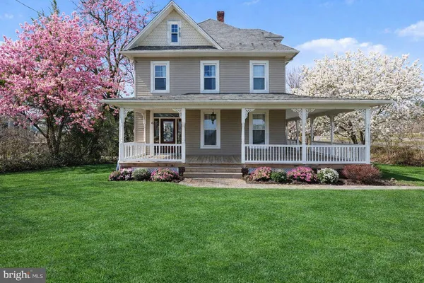 a front view of a house with a garden and trees