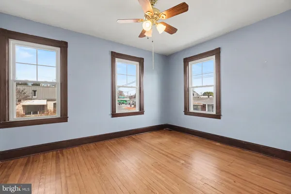 a view of an empty room with window and wooden floor