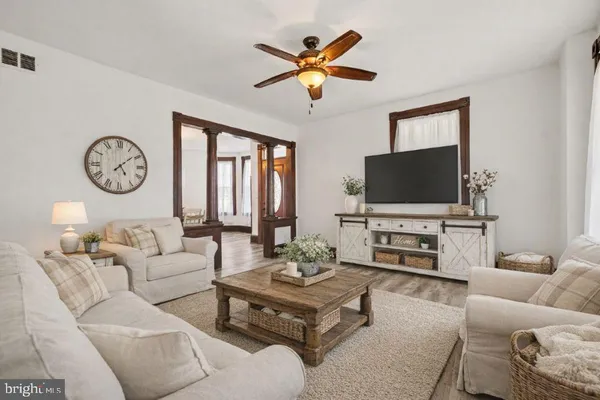 a living room with furniture a flat screen tv and a window