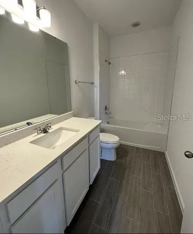 a bathroom with a sink a toilet a shower and a mirror