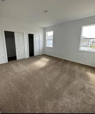 an empty room with windows and closet