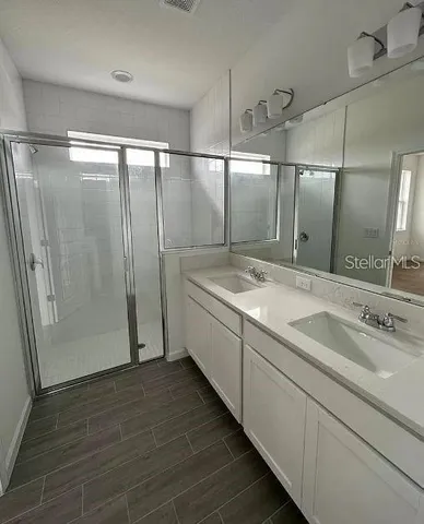 a bathroom with a double vanity sink and mirror