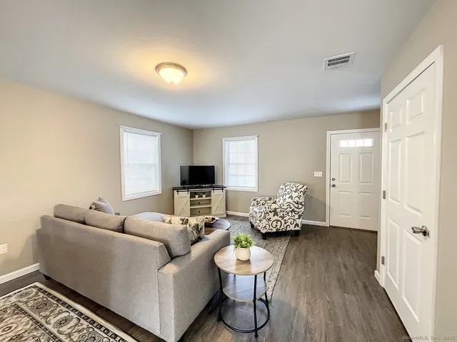a living room with furniture and a wooden floor