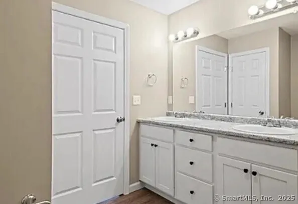 a bathroom with a granite countertop sink and a mirror