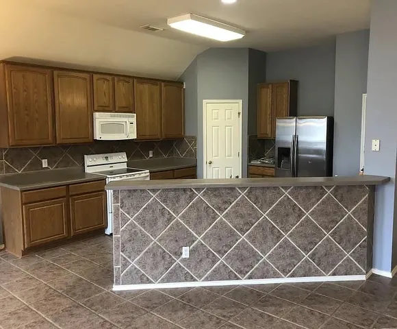 a kitchen with a sink cabinets and wooden floor