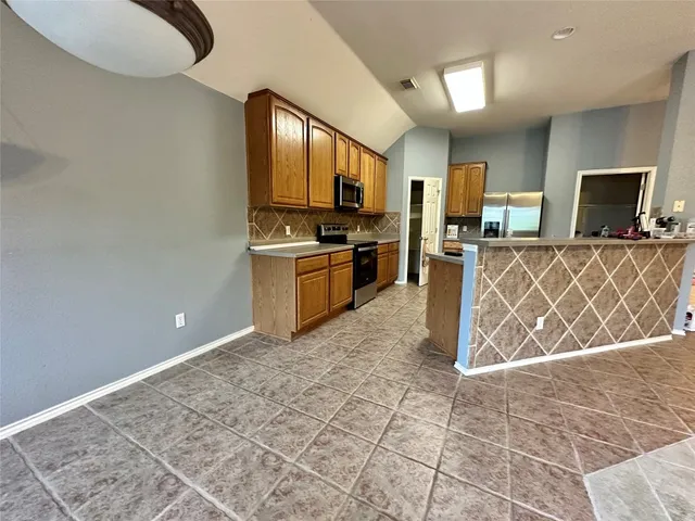 a large kitchen with a stove a sink and a microwave