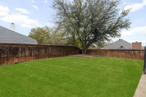 a view of backyard with wooden fence