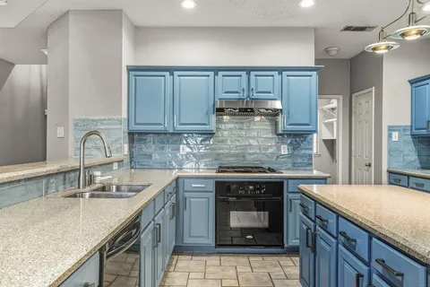 a kitchen with a sink stove and cabinets