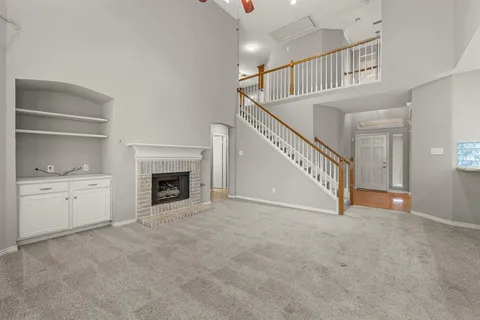 a view of an empty room with a fireplace and a window
