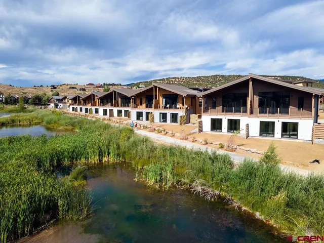 an aerial view of a house with a yard garage and lake view