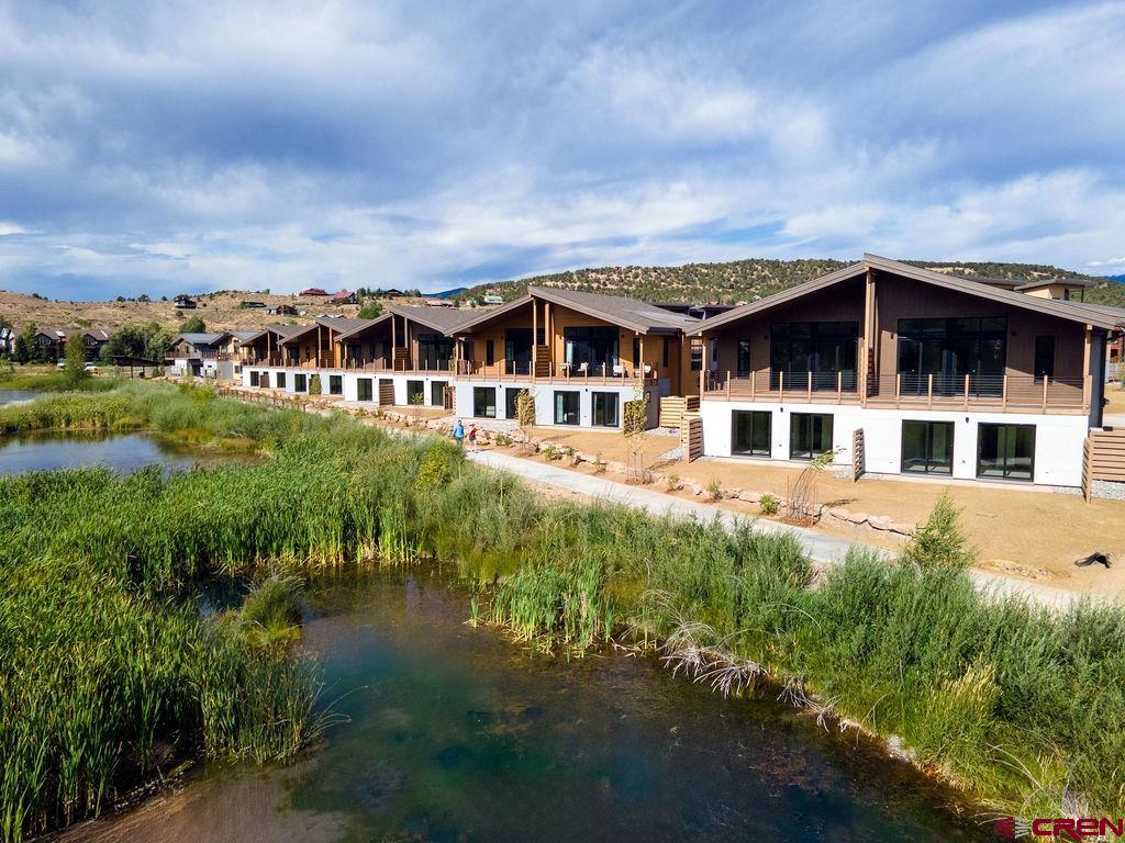 199 Riverfront Lane, Unit 101 Ridgway, CO 81432 - Photo 8 of 21 a view of a big house with a big yard and large trees