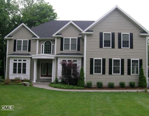 a view of a white house with a yard and plants