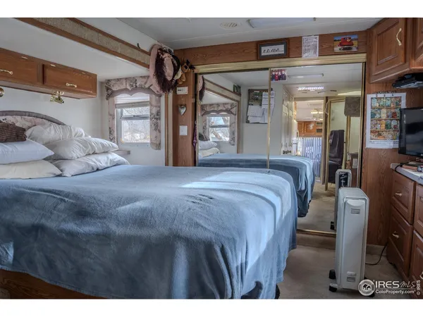 a spacious bedroom with a bed a mirror and dresser