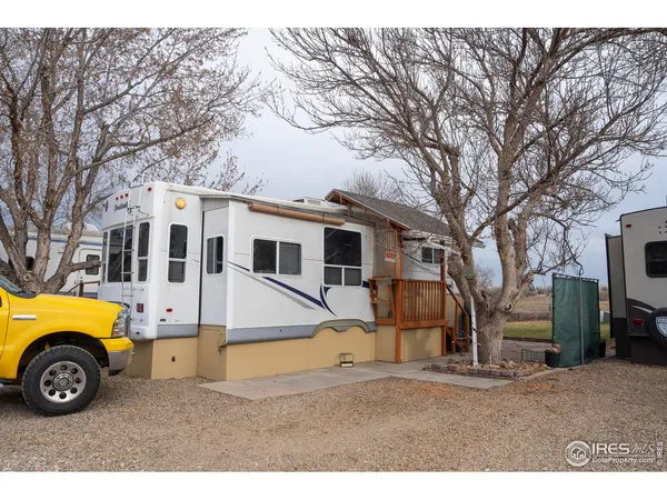 a view of a white house next to a road and yard