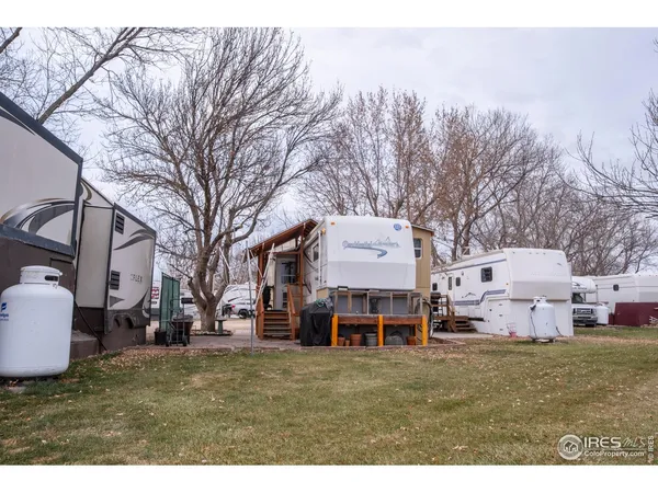 a front view of a house with a garden and chairs
