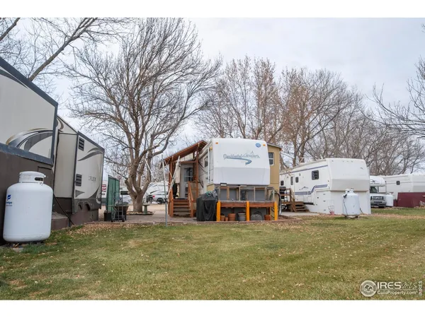 a front view of a house with a garden and chairs