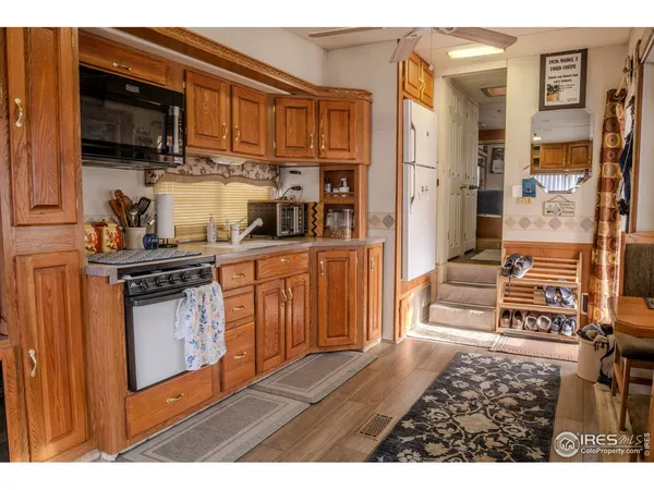 a kitchen with stainless steel appliances granite countertop a stove top oven a sink dishwasher and cabinets with wooden floor