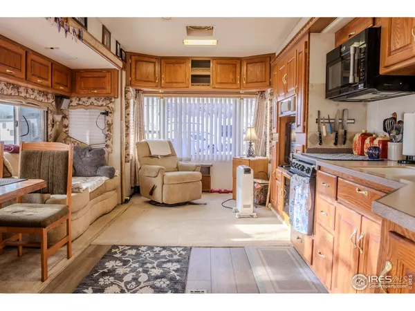 a living room with furniture a flat screen tv and kitchen view