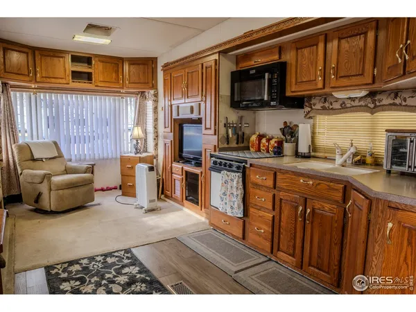 a kitchen with stainless steel appliances granite countertop a stove a sink dishwasher and a microwave oven with cabinets