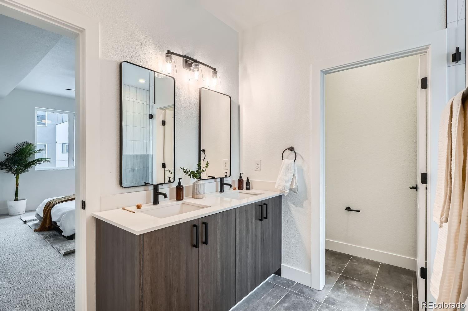 10151 West 38th Avenue Wheat Ridge, CO 80033 - Photo 12 of 50 a bathroom with a double vanity sink and mirror