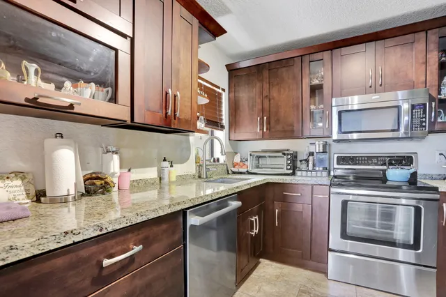 a kitchen with stainless steel appliances granite countertop a sink stove and microwave