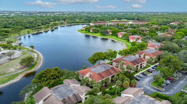 an aerial view of a house with a garden and lake view