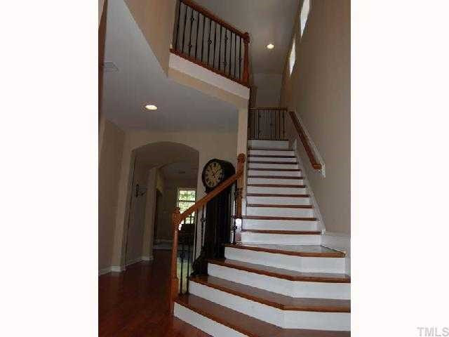 6227 Oconner Street Raleigh, NC 27617 - Photo 2 of 11 Hardwood floor, open staircase, upgraded chandelier, recessed light, painted crown molding, designer neutral wall paint, insulated front door, 2 side light windows with 2" blinds, smooth 2 story ceiling Foyer