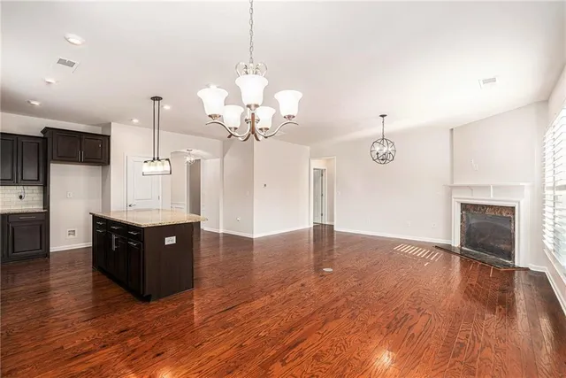 a large room with wooden floor and stainless steel appliances