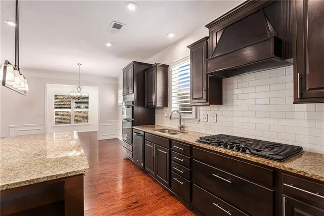 a kitchen with stainless steel appliances granite countertop a stove and a wooden cabinets