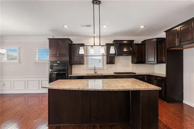 a kitchen with stainless steel appliances granite countertop a sink a stove and a refrigerator