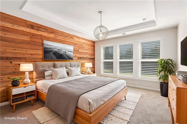 a spacious bedroom with a bed and a chandelier