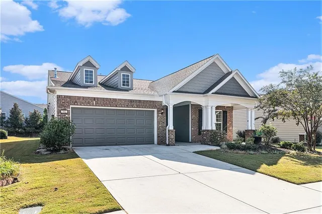 a front view of a house with yard and parking