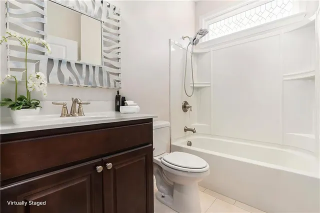 a bathroom with a sink a toilet a mirror and shower