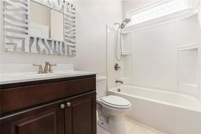 a bathroom with a sink a toilet a mirror and shower