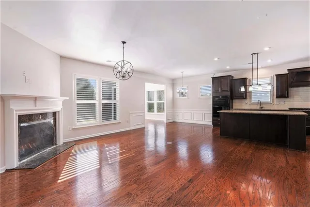 a view of kitchen with granite countertop wooden floor a refrigerator and a sink