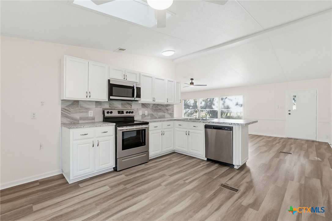 2739 Willow Loop Kempner, TX 76539 - Photo 11 of 30 a kitchen with granite countertop white cabinets and stainless steel appliances