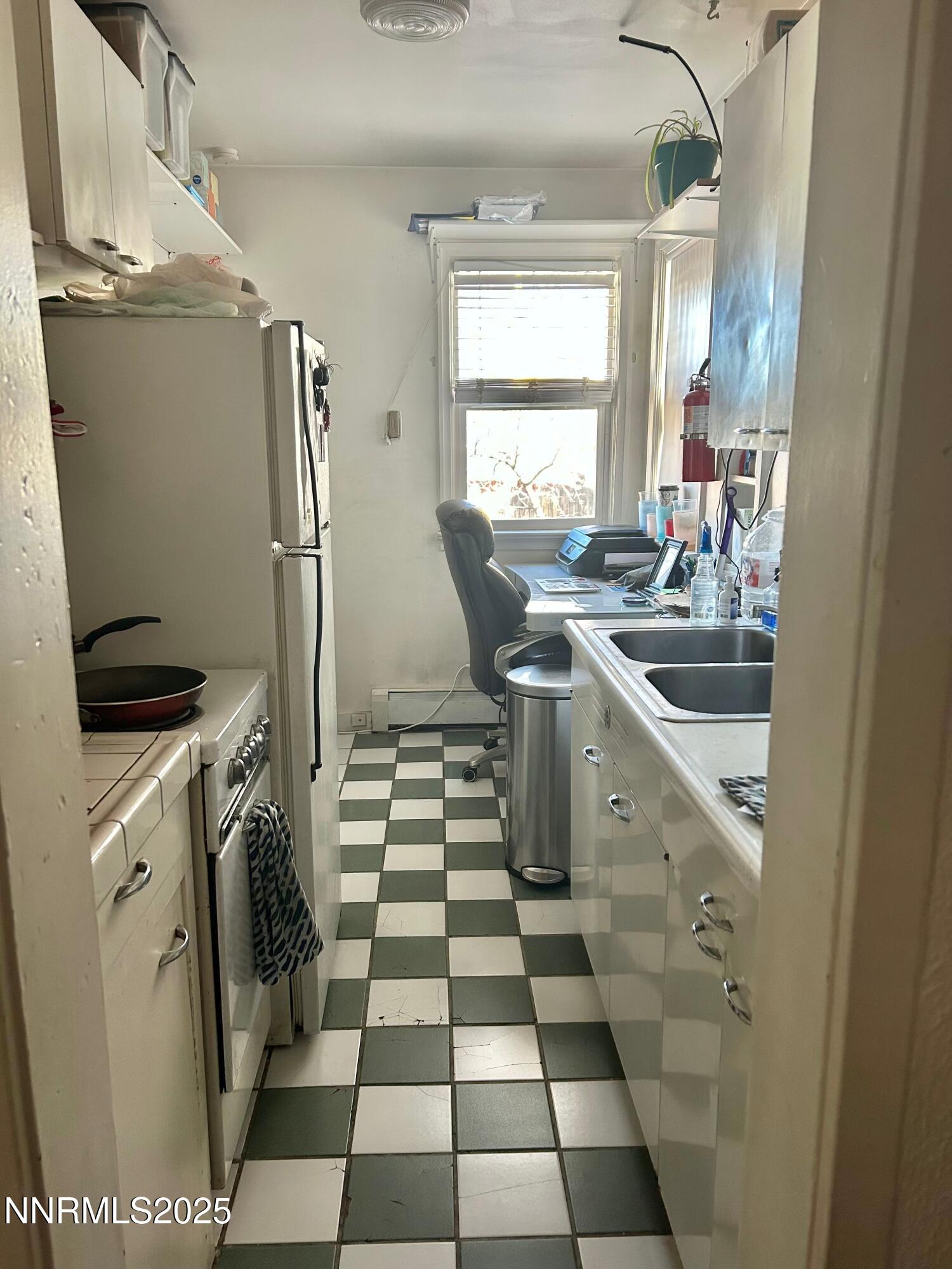 1170 Forest Street Reno, NV 89509 - Photo 28 of 32 a kitchen with a sink a refrigerator and cabinets