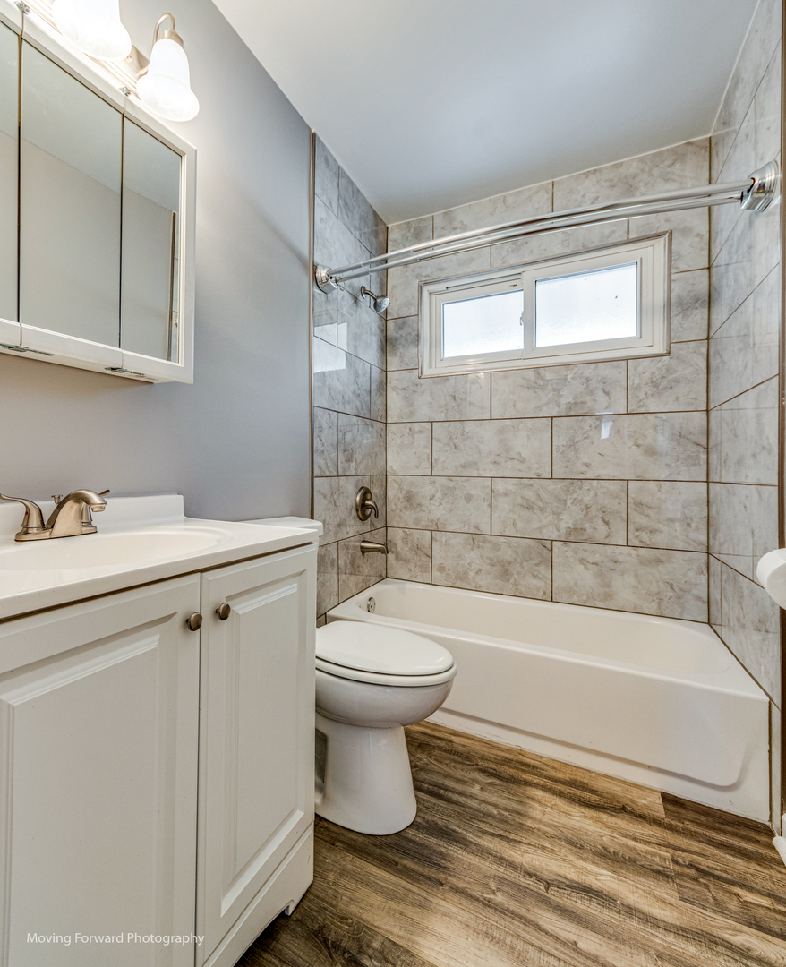 147 Queenswood Road Bolingbrook, IL 60440 - Photo 14 of 20 a bathroom with a sink a toilet and bathtub